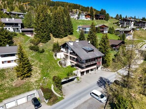 Una zona residencial con casas modernas, una calle y un automóvil.