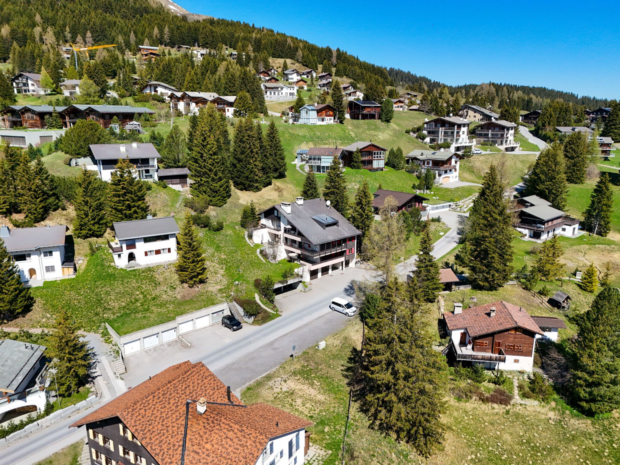 Un quartier résidentiel avec des maisons, une route et une montagne en arrière-plan.