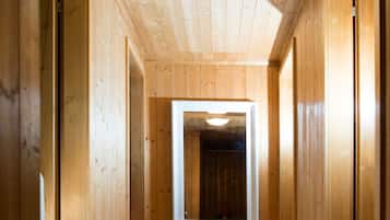 Ein Holzflur mit einem rechteckigen Fenster in der Mitte und einer Deckenleuchte.