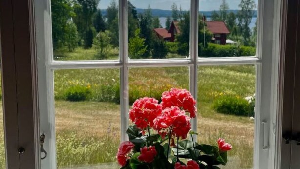 A window with a view of a rural landscape, including fields and houses. - Summer House Sweden in Rättvik for 9 people by Interhome (Rättvik)