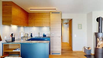 Una cocina moderna con armarios de madera, una isla central y un estufa de leña.