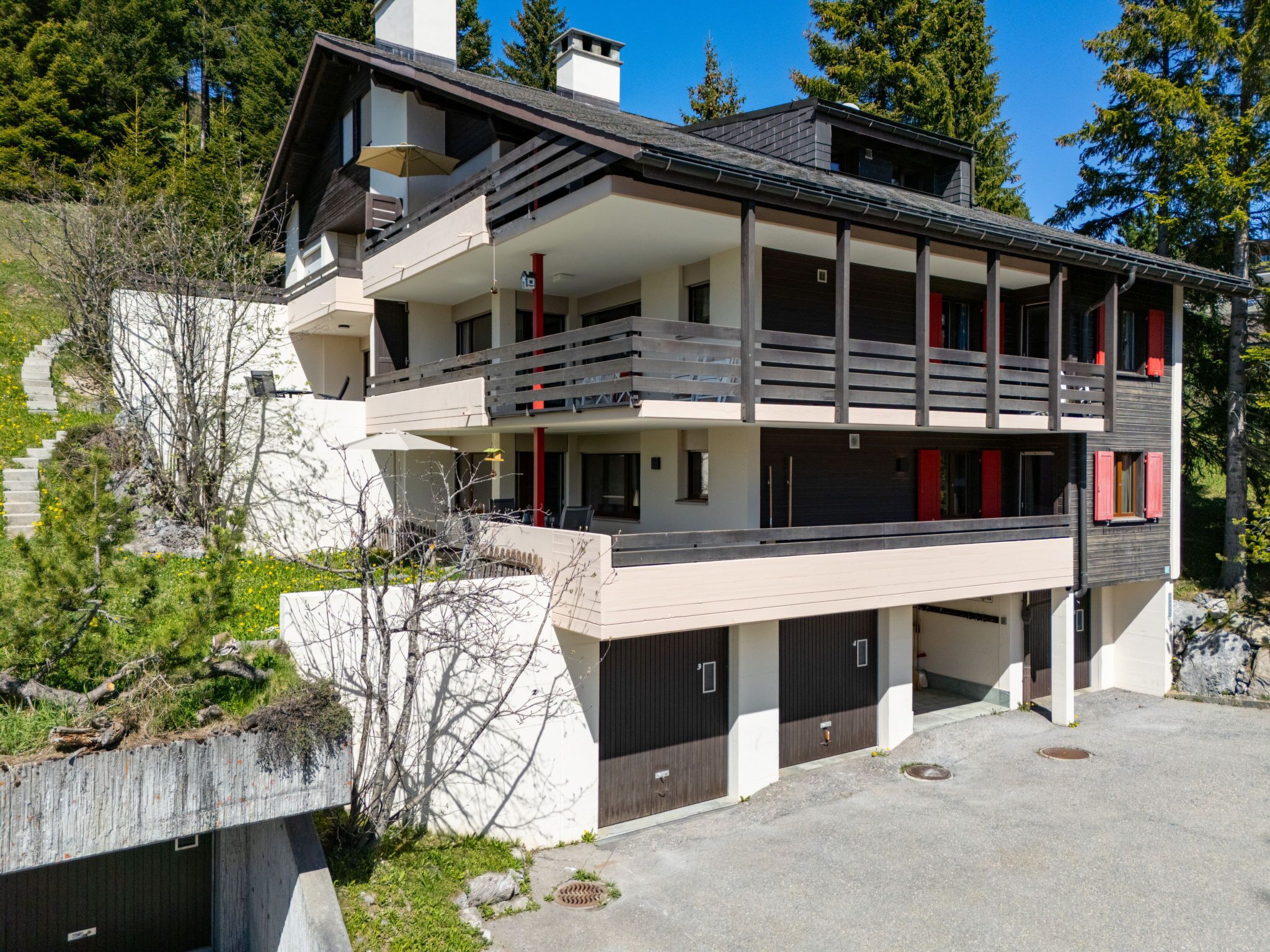 Un edificio de varios pisos con balcón, garaje y entrada para vehículos.