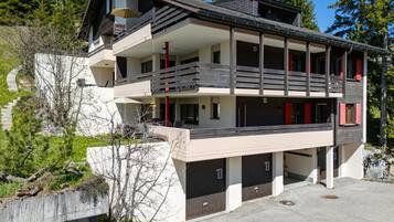 Un edificio de varios pisos con balcón, garaje y entrada para vehículos.