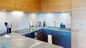 Uma cozinha moderna com armários de madeira, bancada de granito e eletrodomésticos de aço inoxidável.