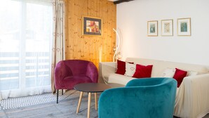 A living room with a sofa, two chairs, a small table, and a patterned rug. - 1505 Chesa Katja by Interhome (Valbella)