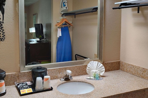 A bathroom with a sink, mirror, towel rack, and toiletries. - Quality Inn Flagstaff East I-40 (Flagstaff)