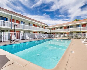 A hotel with a swimming pool, white balconies, and lounge chairs. - Quality Inn Flagstaff East I-40 (Flagstaff)
