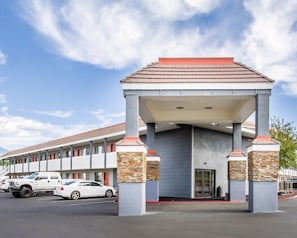 A motel with a covered entrance, stone pillars, and a parking lot with cars. - Quality Inn Flagstaff East I-40 (Flagstaff)