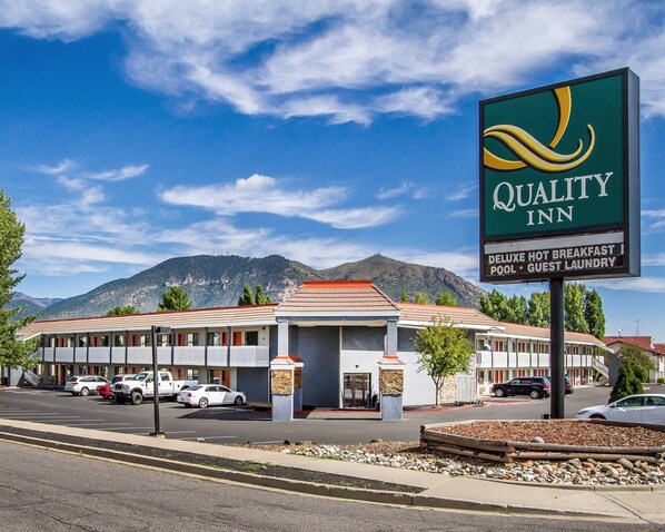 A Quality Inn with a signboard, a parking lot, and a mountainous backdrop. - Quality Inn Flagstaff East I-40 (Flagstaff)