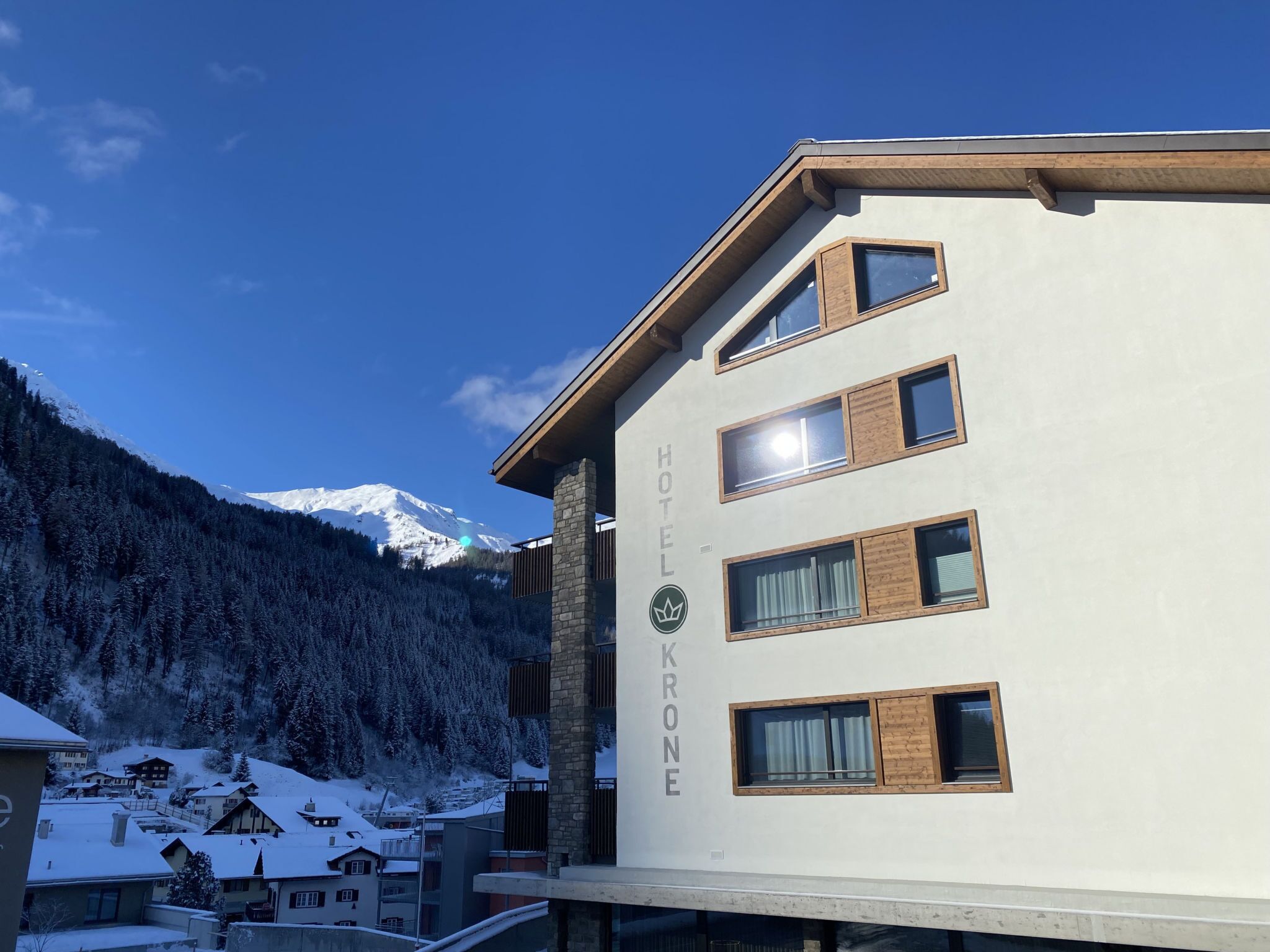 A hotel building with multiple windows and a mountain in the background.