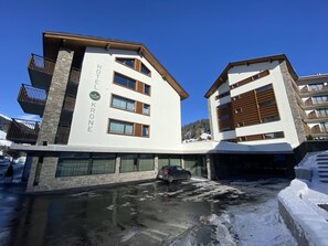 Un hôtel au design moderne, caractérisé par une façade en pierre et de nombreux balcons.