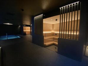 Un área de spa moderna con sauna, piscina y zona de relajación.