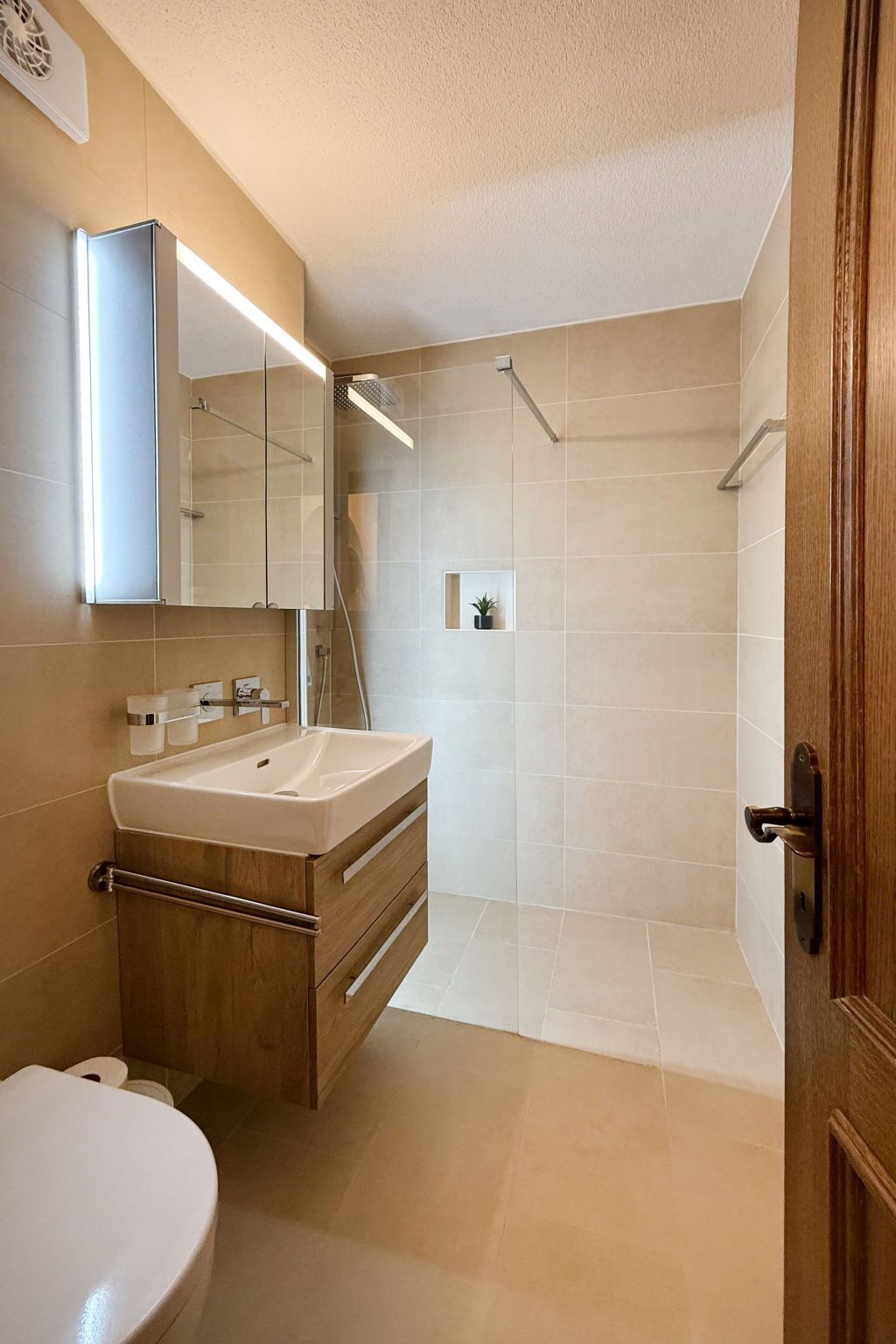 Une salle de bain moderne avec un lavabo, un miroir et une douche.
