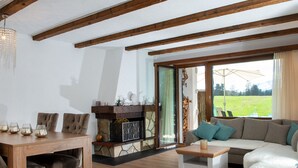 A cozy living room with a wooden dining table, a sofa, and a fireplace. - 1507 Davos Lai Valbella by Interhome (Valbella)