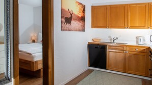 A compact hotel room with a bed, a small kitchenette, and a bathroom. - 1507 Davos Lai Valbella by Interhome (Valbella)