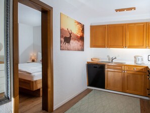Habitación de hotel compacta con cama, kitchenette pequeña y baño.