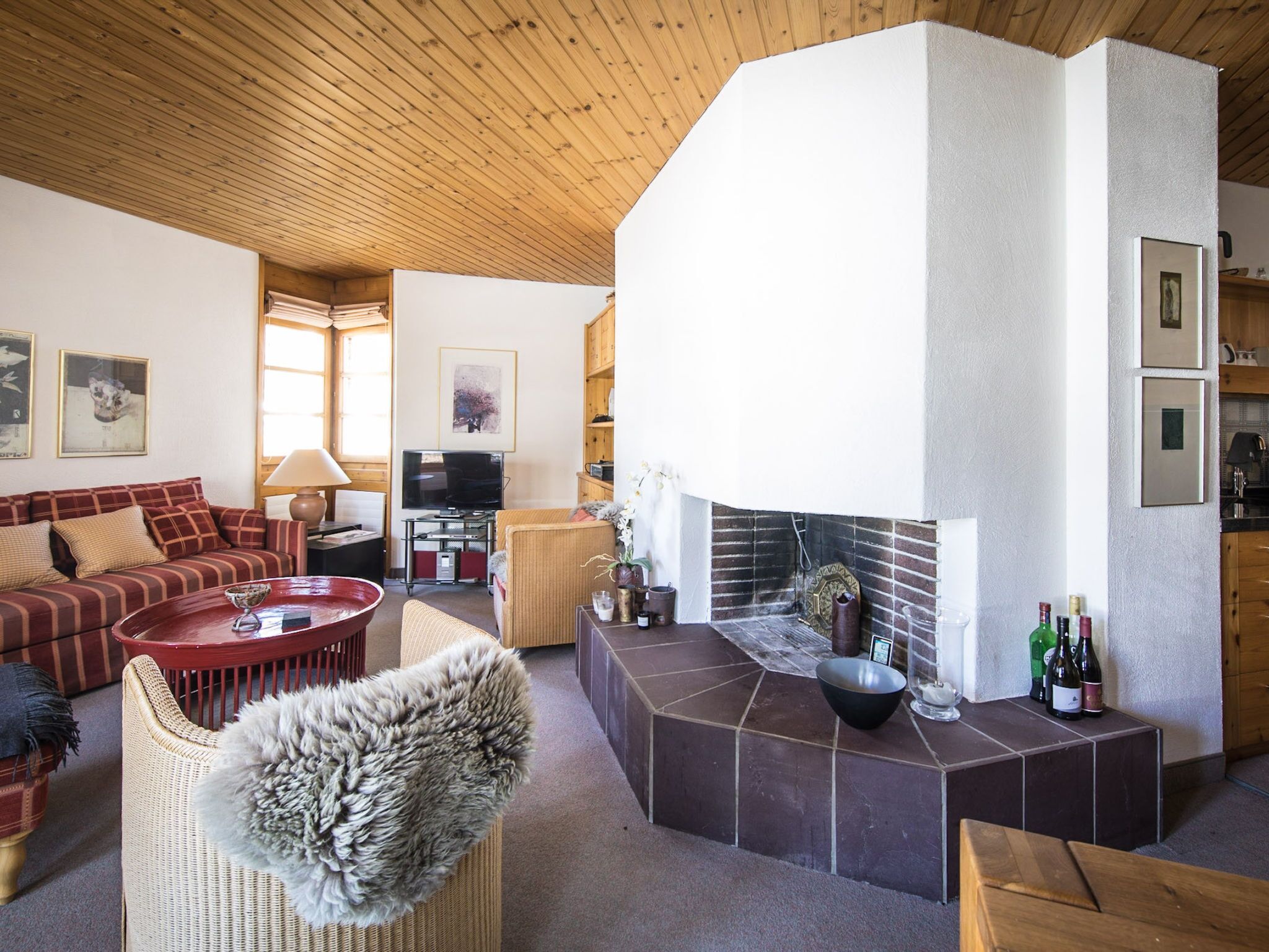 Ein gemütliches Wohnzimmer mit Kamin, bequemen Sitzmöglichkeiten und einem Fernseher.