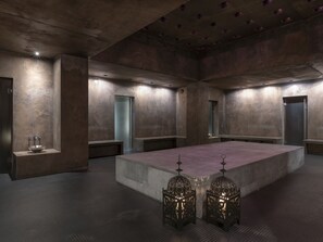 A spacious, modern bathroom with a large central sink, benches, and decorative lanterns. - 1604 Schweizerhof 405 by Interhome (Lenzerheide)