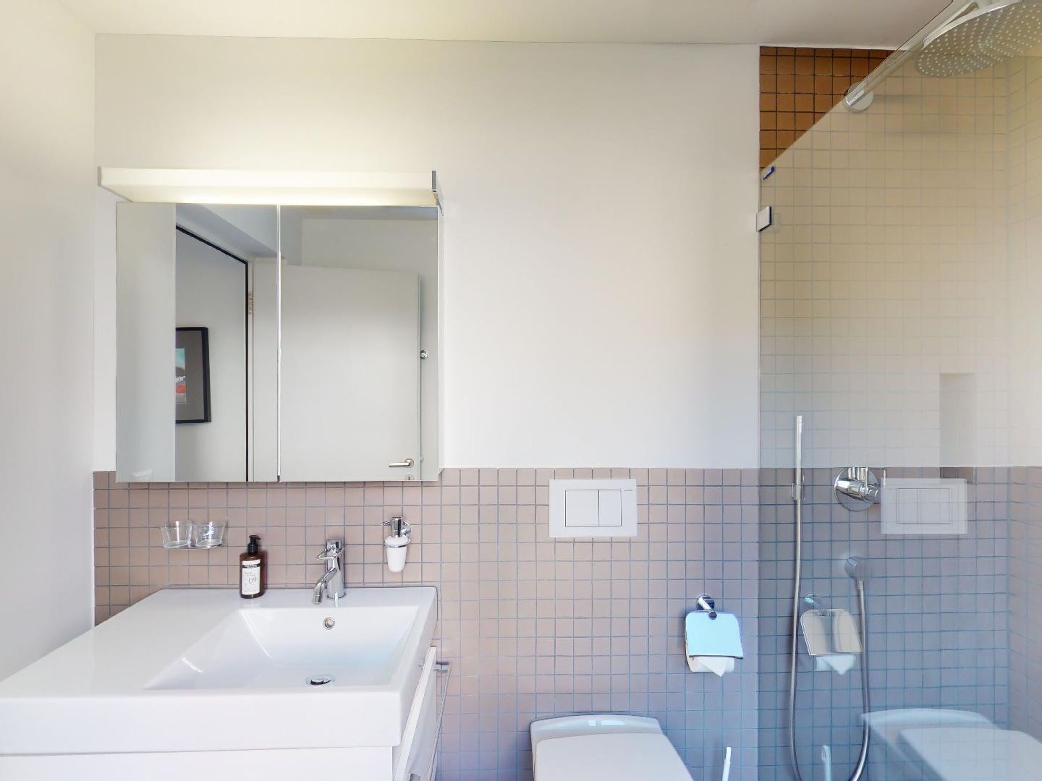 Une salle de bain moderne avec un grand lavabo blanc, un miroir et un espace douche.