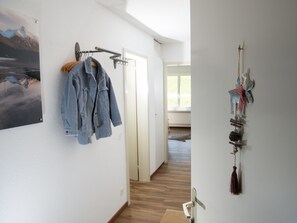 A hallway with a coat rack, a wall-mounted decoration, and a wooden floor. - 1611 Pianura Crapera by Interhome (Lenzerheide)