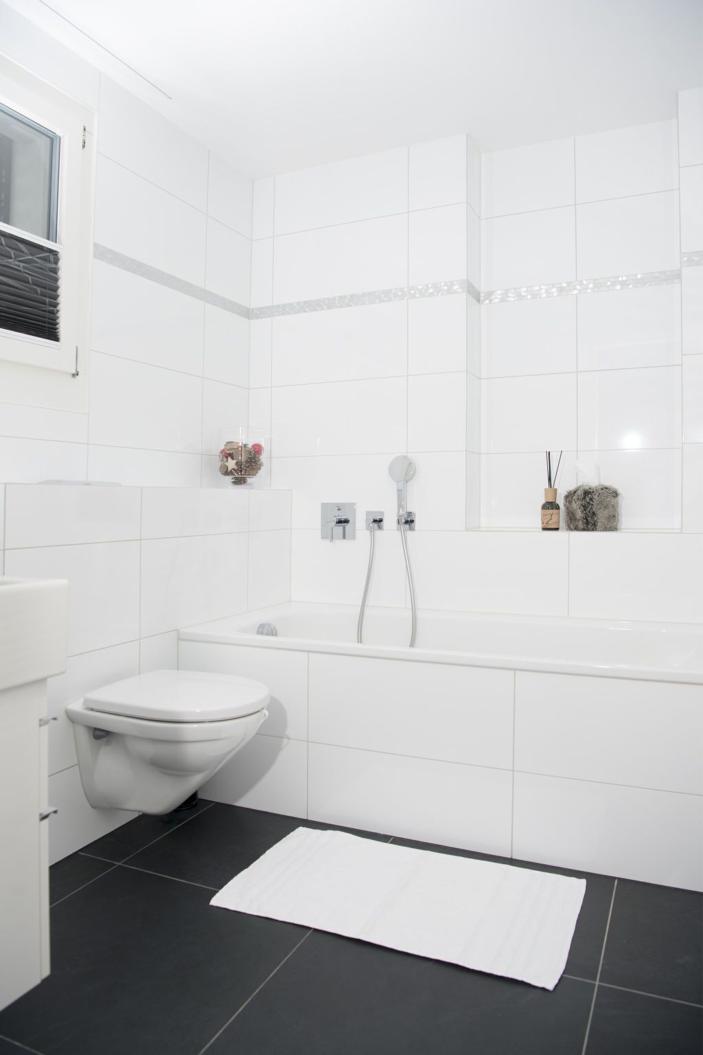 Ein modernes Badezimmer mit Toilette, Badewanne und Dusche.