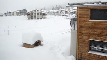 Ein verschneiter Wohnbereich mit Häusern und einem Holzhaus.