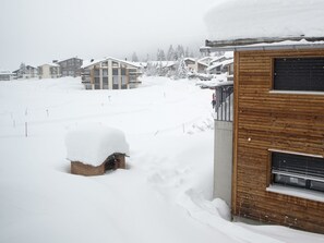 Un quartier résidentiel enneigé, avec des maisons et un bâtiment en bois.