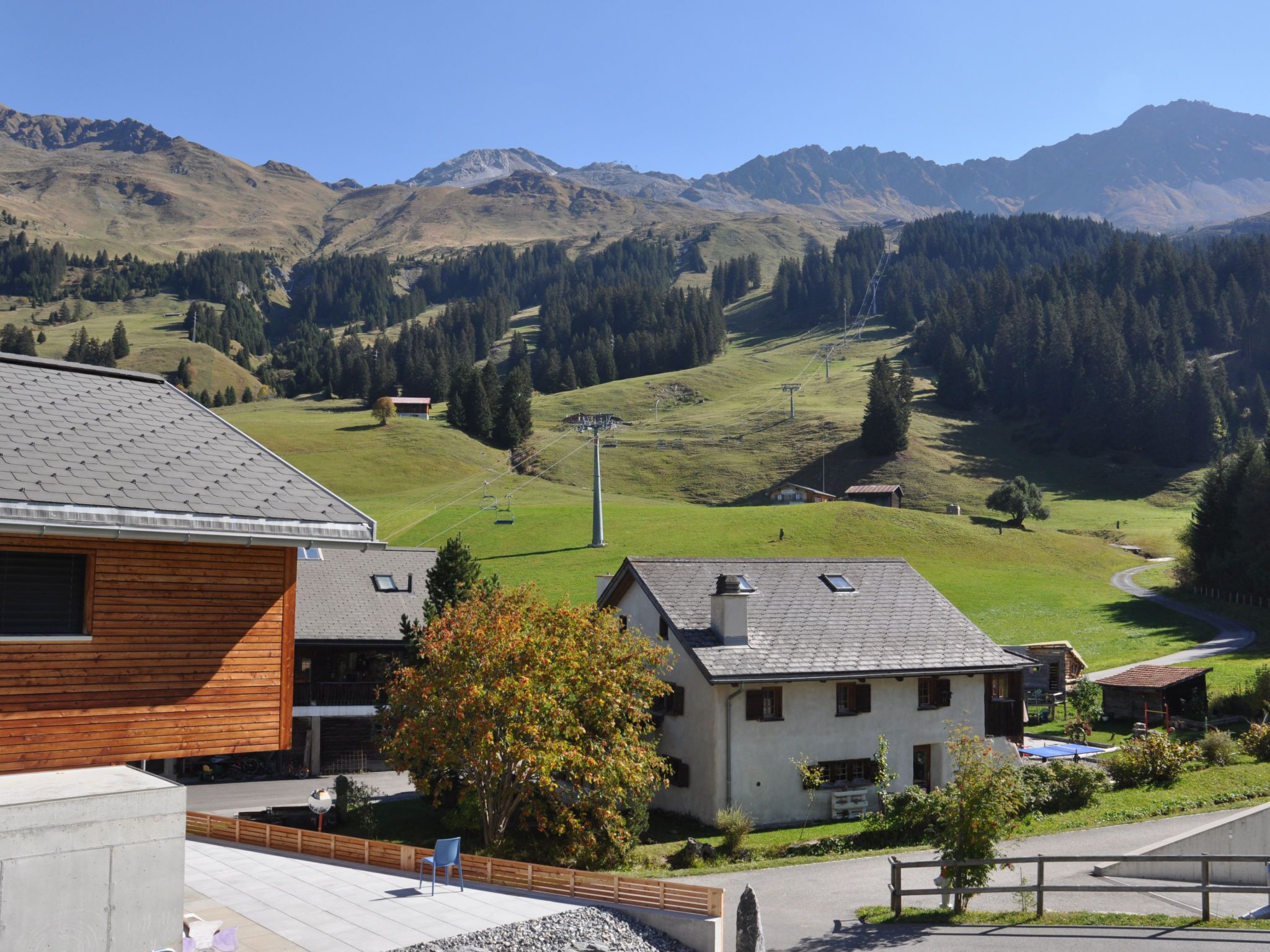 A residential area with houses, a clear sky, and mountains in the background.