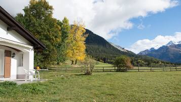 Ein Gebäude mit Veranda, Tisch und Stühlen.