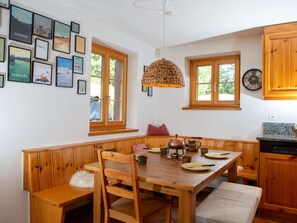 A wooden dining table with chairs, a bench, and a hanging light fixture. - 1608 Acla Pala by Interhome (Lenzerheide)