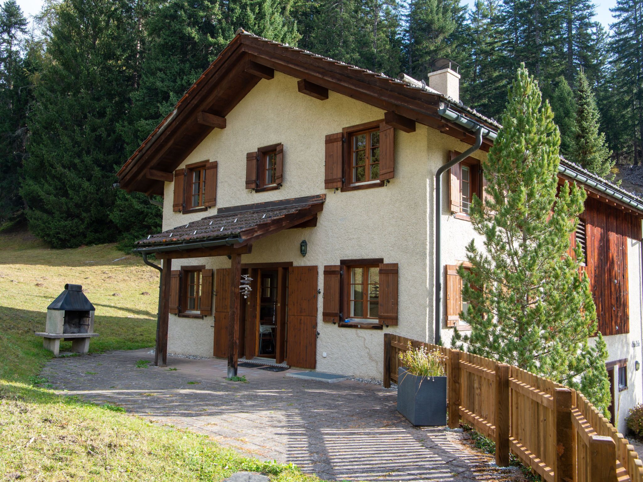 Ein zweistöckiges Haus mit geneigtem Dach, Holzhörnern und einem Schornstein.
