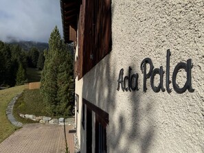 Un edificio con un cartel que dice 'Ada Palat' sobre una pared con textura.