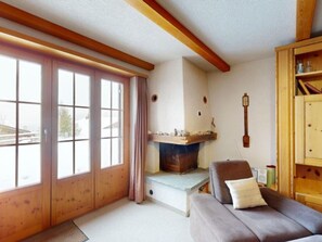 Une pièce chaleureuse avec une cheminée, un canapé et un meuble en bois.