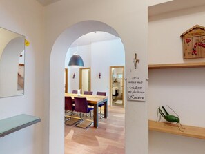 A modern interior with an arched doorway leading to a dining area with a table and chairs. - 1607 Palois by Interhome (Lenzerheide)