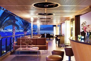 A rooftop bar with a view of the sea, seating arrangements, and a wooden ceiling design. - Spetses (Spetses)