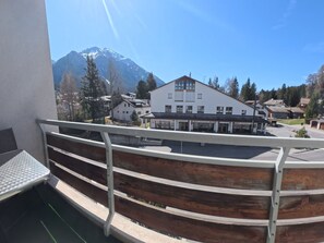 A balcony with a metal railing overlooking a building with a mountain backdrop. - 1618 Lai Zentrum by Interhome (Lenzerheide)