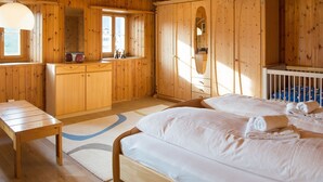 Un dormitorio de cabaña de madera con dos camas, un aparador de madera y una ventana.