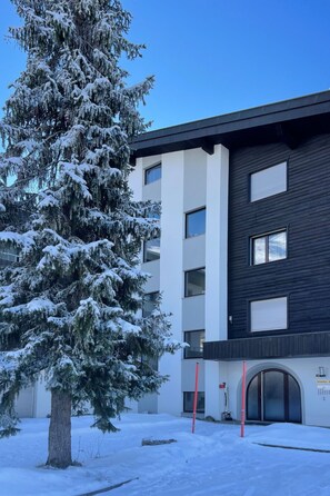 Ein modernes Gebäude mit einem schnee bedeckten Baum davor.