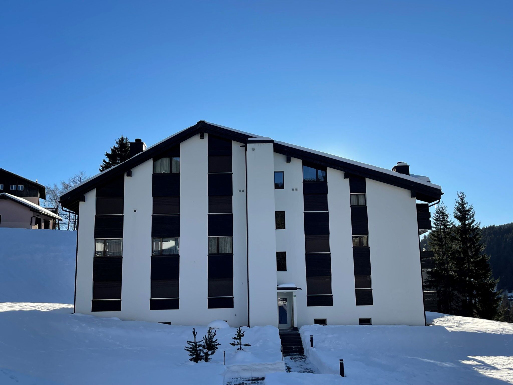 A modern building with a symmetrical facade, large windows, and a flat roof.