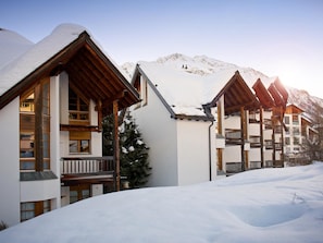 A snow-covered mountain resort with wooden buildings and a clear sky. - Apartment  by Interhome (Lenzerheide)