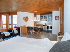 A cozy room with a bed, a desk, and a kitchenette. - Apartment  by Interhome (Lenzerheide)