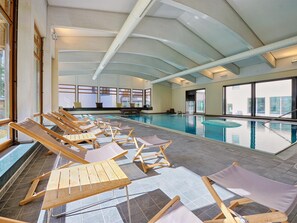 Zona de piscina amb gandules i vista exterior.