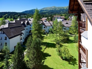 Ein Wohngebiet mit mehreren weißen Gebäuden, grünen Rasenflächen und Bäumen.