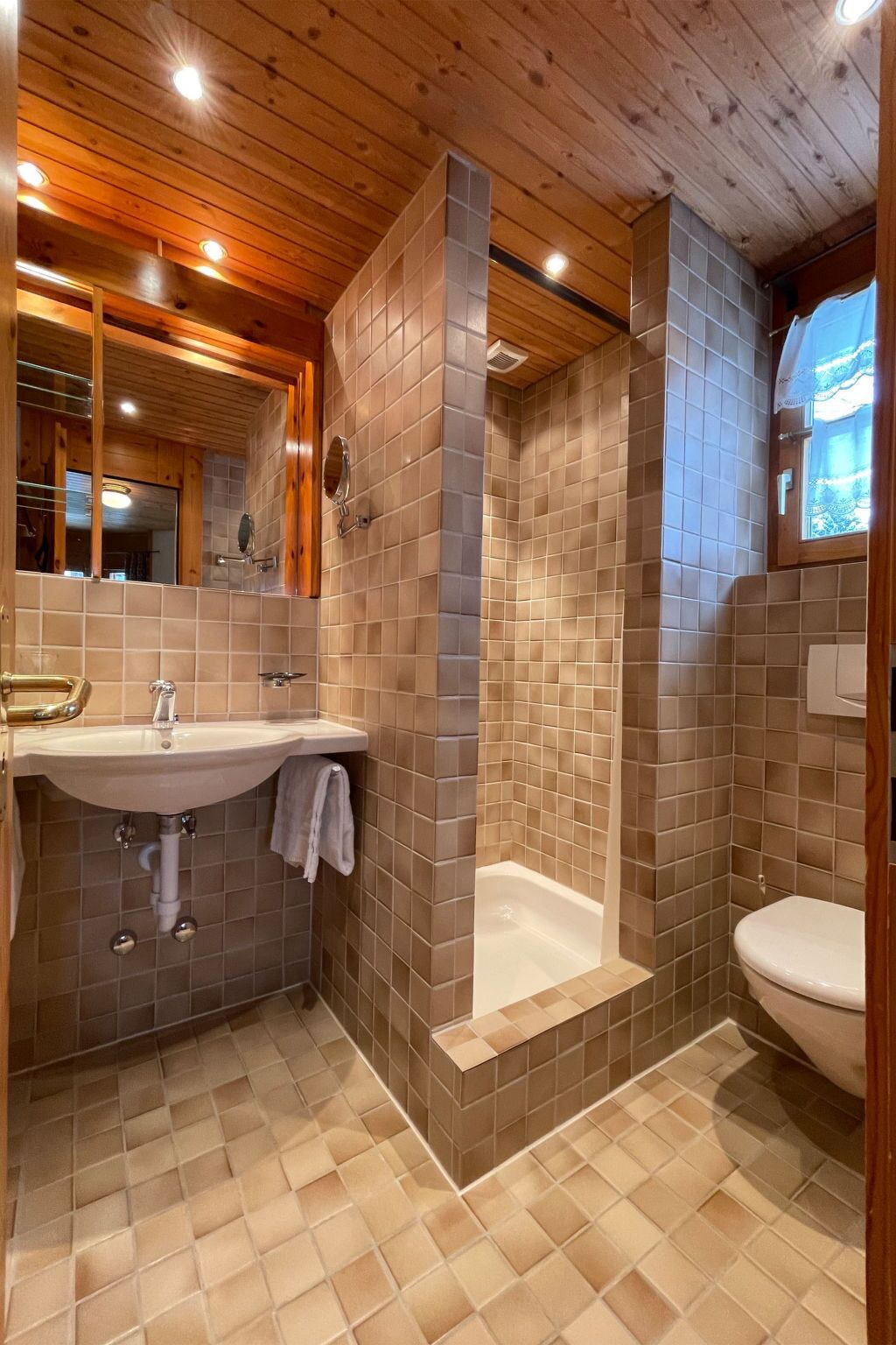 Ein Badezimmer mit Waschbecken, Spiegel, Dusche und Toilette.