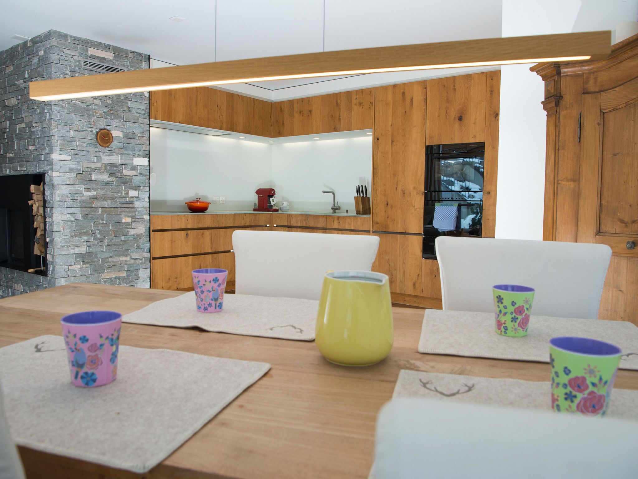 Eine moderne Küche mit einer Steinwand, Holzschränken und einem eingebauten Backofen.