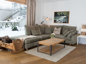 A modern living room with a sectional sofa, a wooden coffee table, and a painting on the wall. - 1907 Valmala by Interhome (Lantsch)