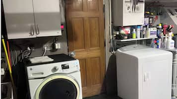 A laundry room with a washing machine, dryer, and cabinets.