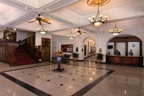 A spacious lobby with a grand staircase, multiple chandeliers, and a reception desk. - Queens Hotel Kandy - 160 Years of Heritage (Kandy)