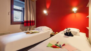 A hotel room with two beds, a window with curtains, and wall-mounted lights. - Residence Pierre et Vacances Balcons de Bellevarde (Val-d'Isere)
