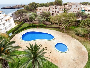 Zona residencial con piscina, exuberante vegetación y vista al mar.